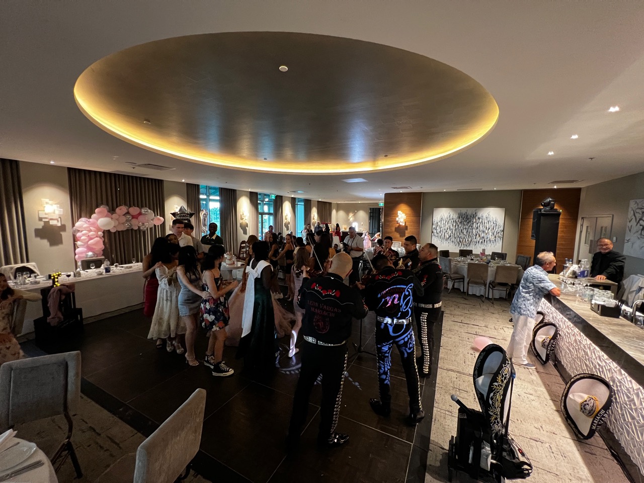 Mariachis rodeados de invitados en la pista de una Quinceañera