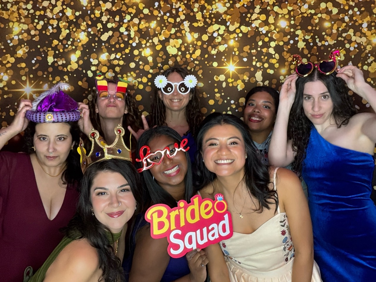 Mariée et amies réunies au photobooth numérique avec des accessoires festifs