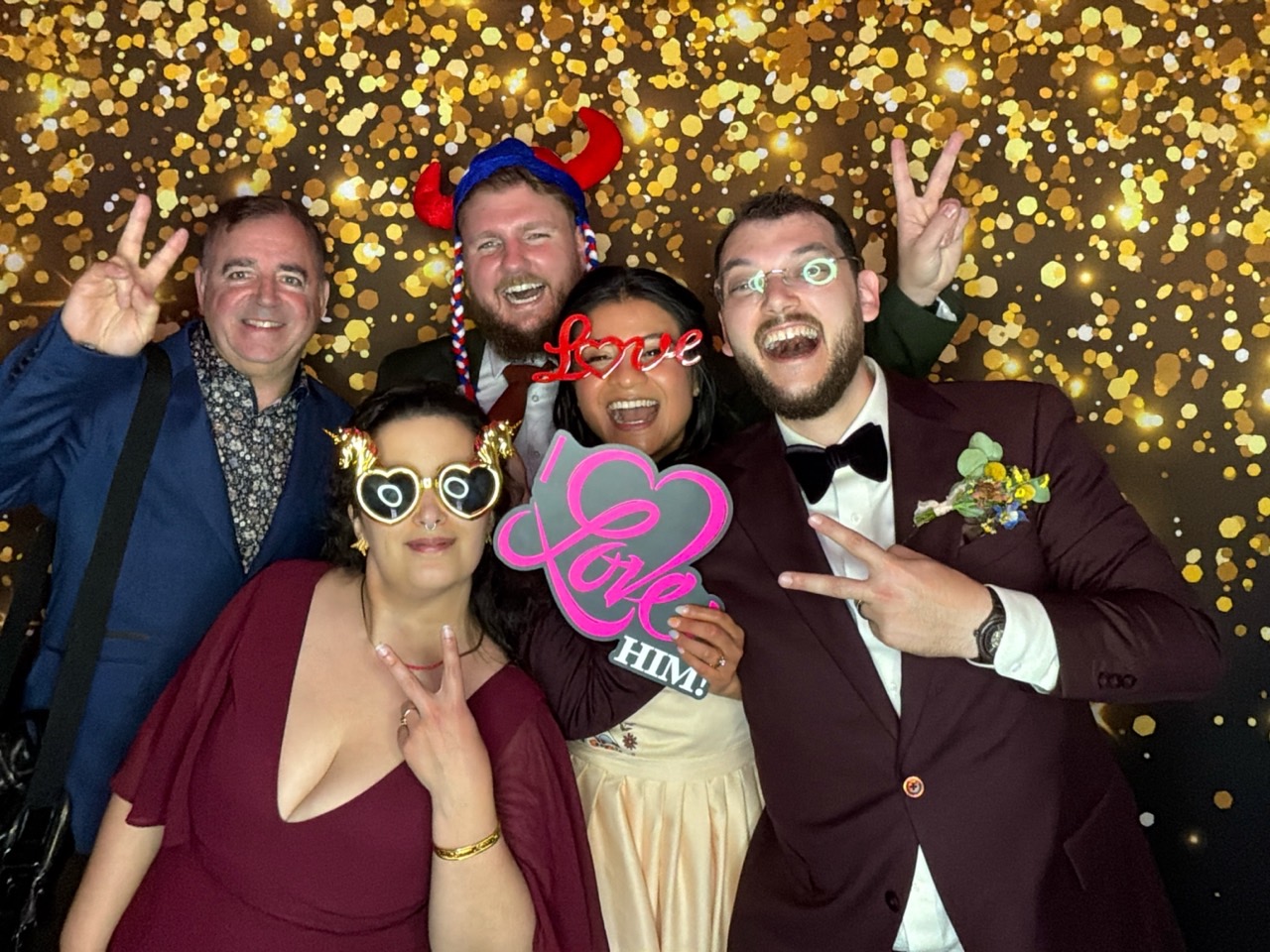 Newlyweds and friends posing together at a digital wedding photo booth