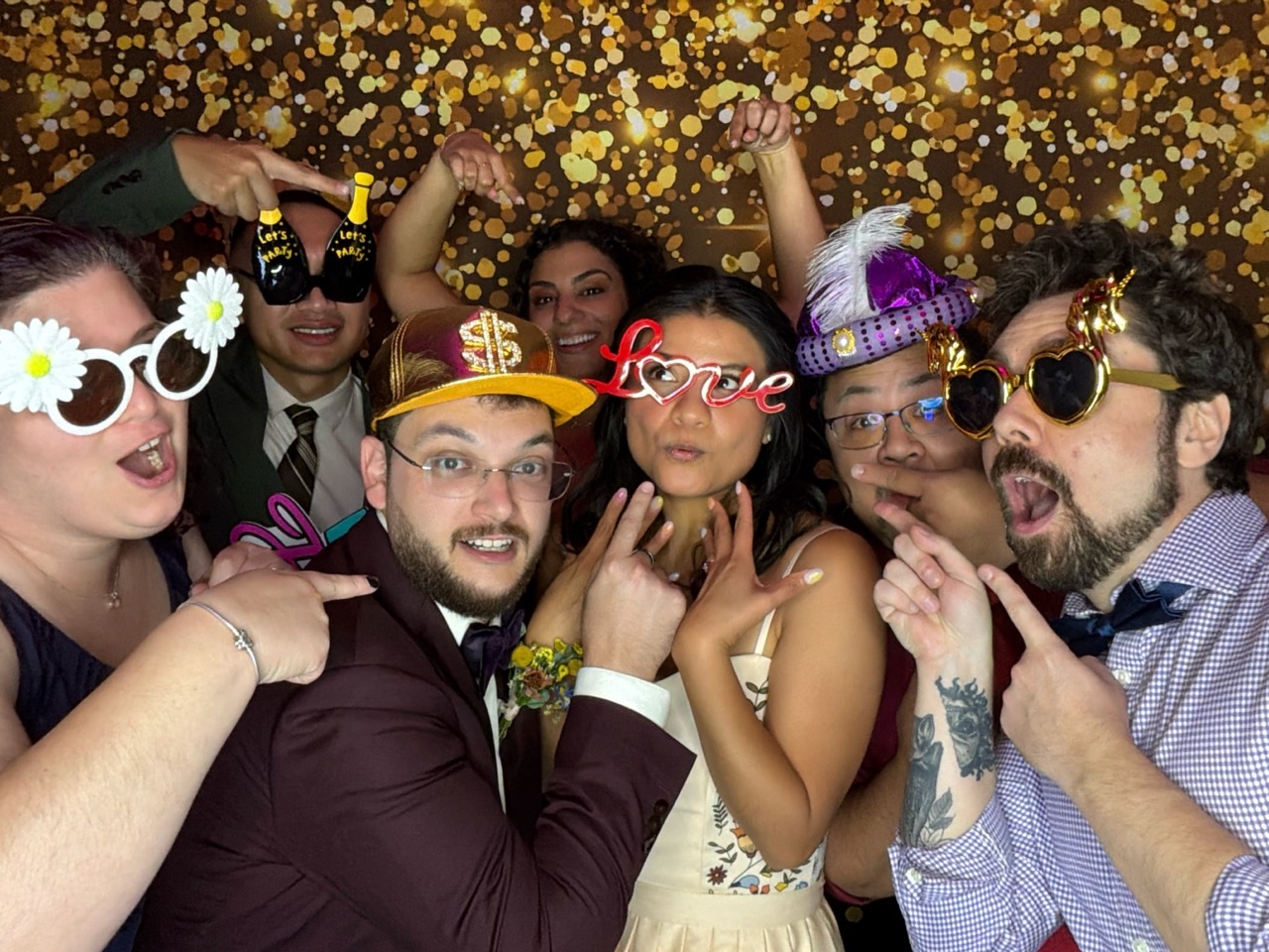 Mariés et invités réunis au photobooth numérique pendant une réception de mariage